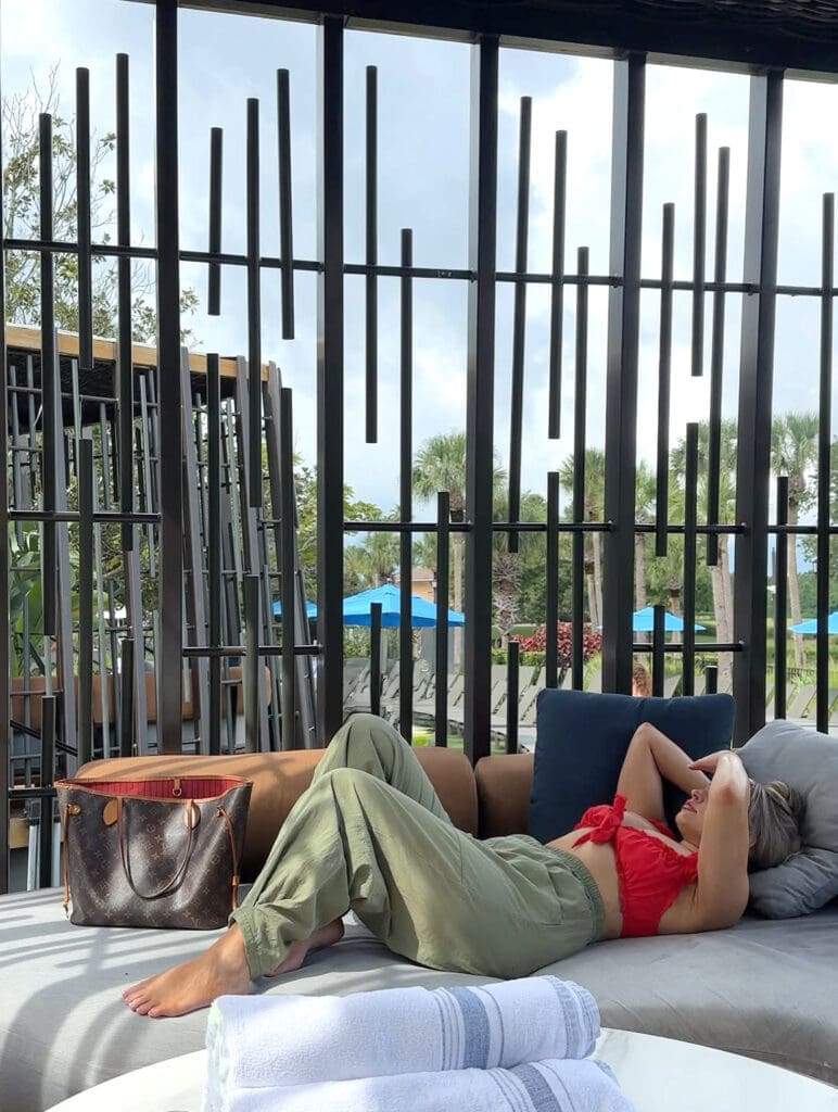 Nicole relaxing in a private Oasis Cabana at JW Marriott Orlando with a Louis Vuitton tote beside her.